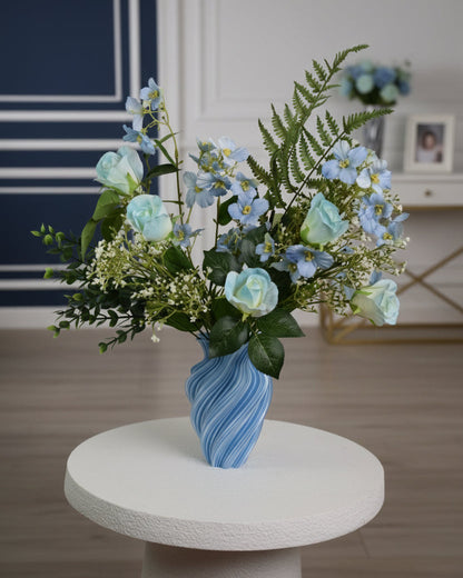 flowerts in a modern blue-toned room with soft natural light, featuring a stylish arrangement of green leaves