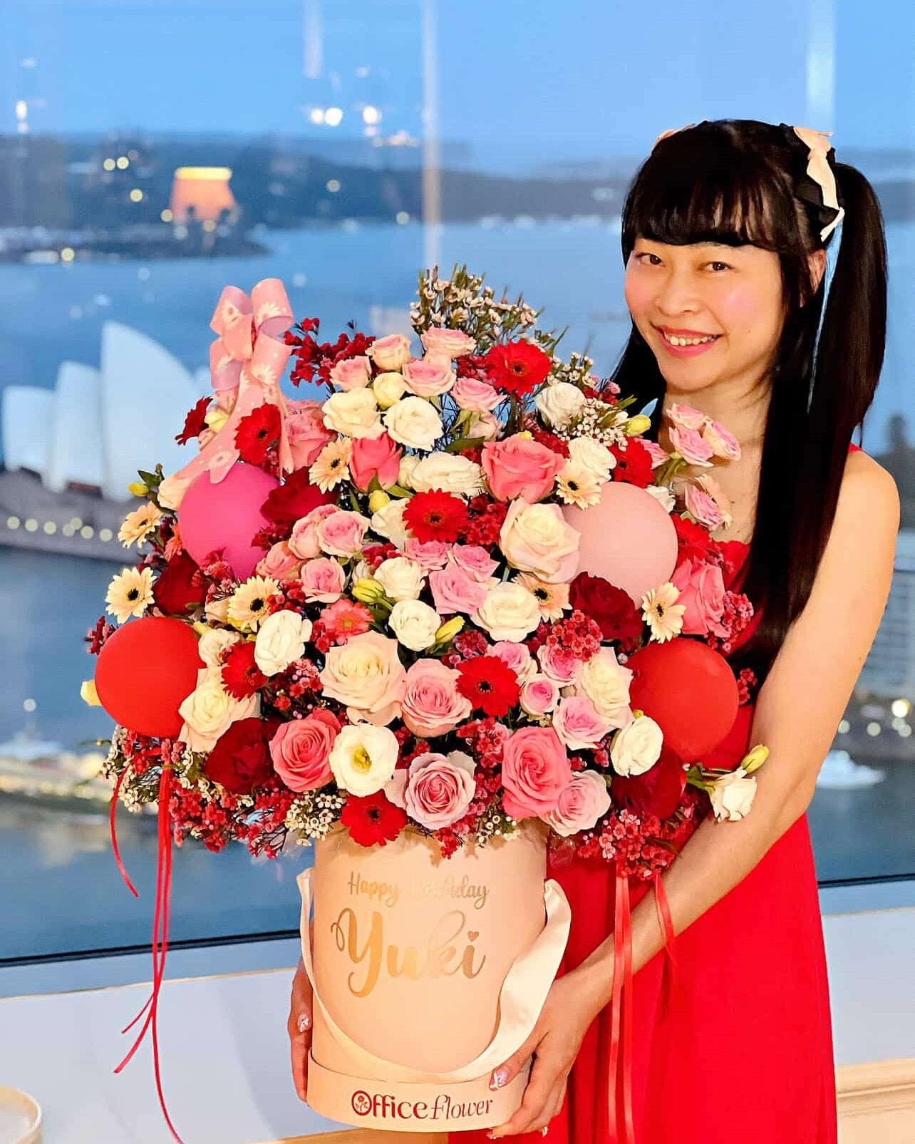 Birthday flower box in a pink gift box with fresh pink roses, red gerberas, and festive pink and red balloons