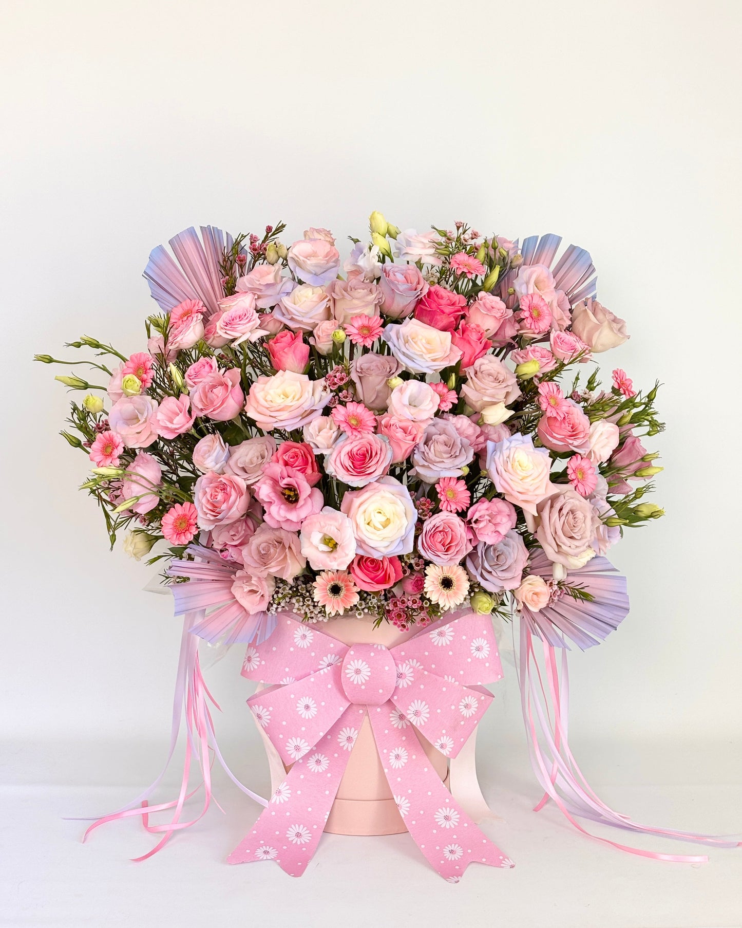 Pastel pink flower box with fresh pink and white roses, ribbon, and soft filler flowers