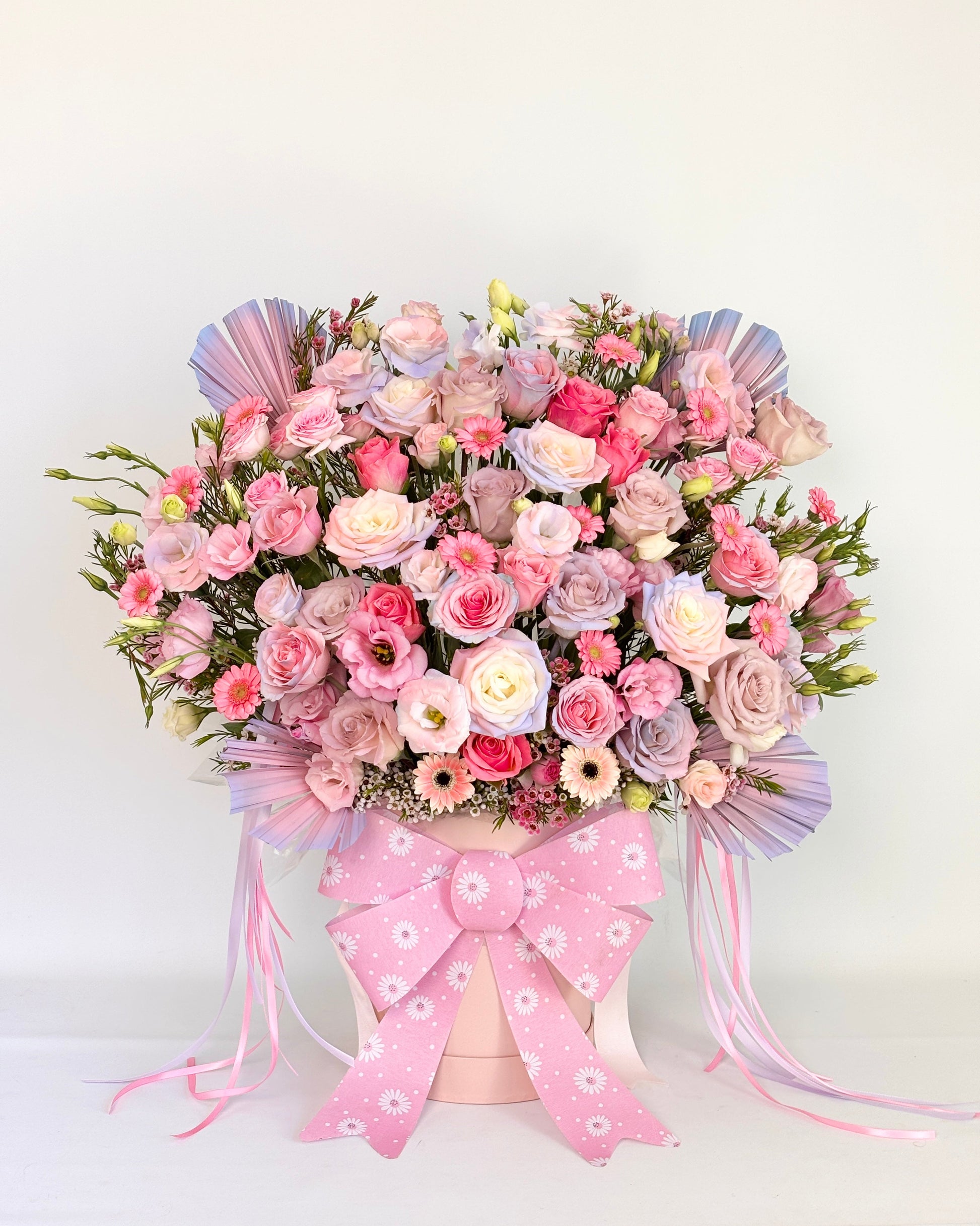 Pastel pink flower box with fresh pink and white roses, ribbon, and soft filler flowers