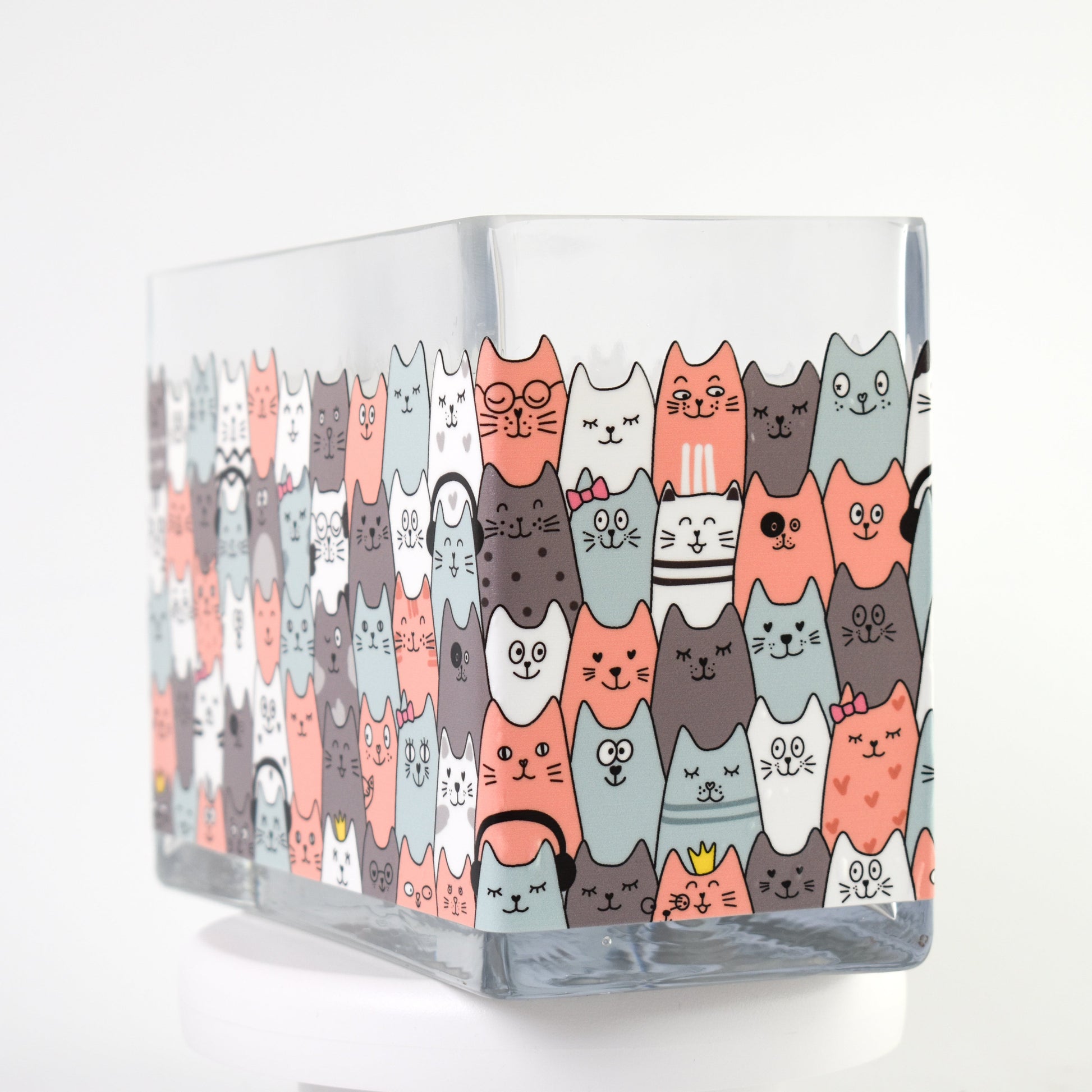 Clear glass vase with a colourful pattern of illustrated cats in coral, teal, white, and grey — size 20x10x15 cmH.