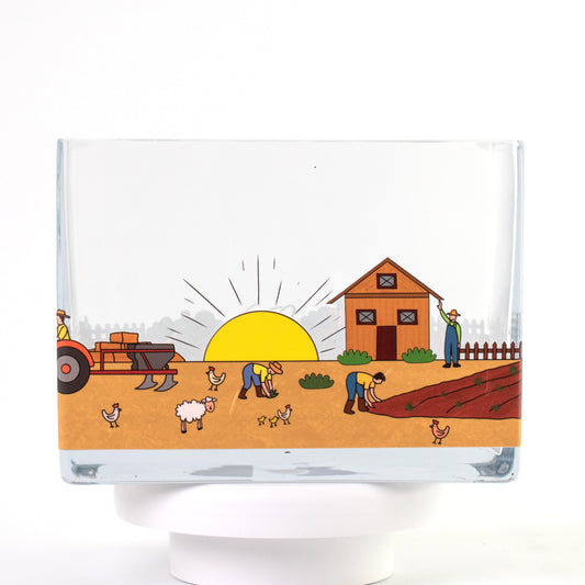 Clear glass vase with a colourful farm design featuring sunrise, barn, farmers, tractor, and animals — size 20x10x15 cmH.
