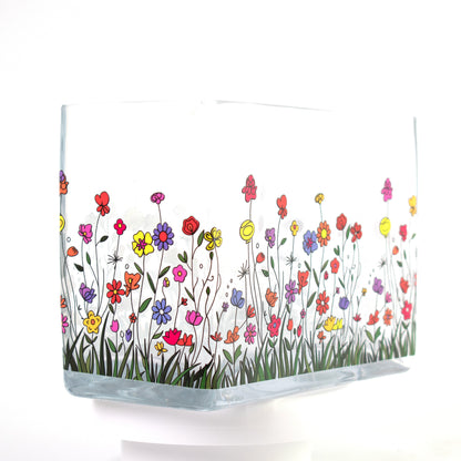 Clear glass vase with a colourful wildflower design featuring red, purple, yellow, and orange flowers — size 20x10x15 cmH.