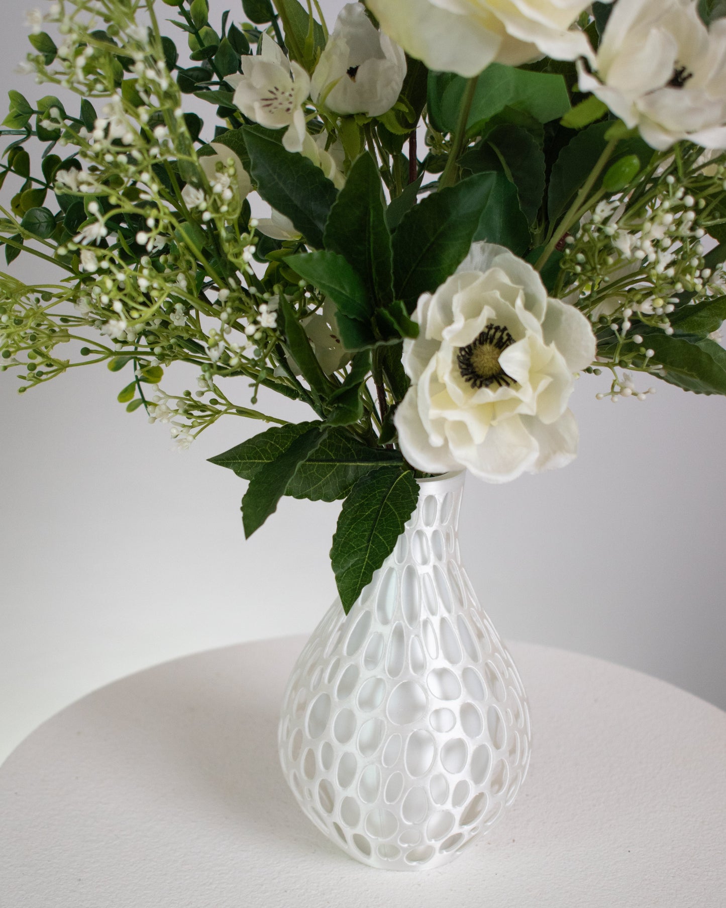 Presented in a modern honeycomb-inspired white vase, this piece blends contemporary design with natural beauty. Perfect for dining tables, entryways, or serene interiors, Ivory Bloom adds a touch of calm and refinement that never fades. With lifelike detail and zero upkeep, it’s the perfect choice for those who love beauty without the maintenance.