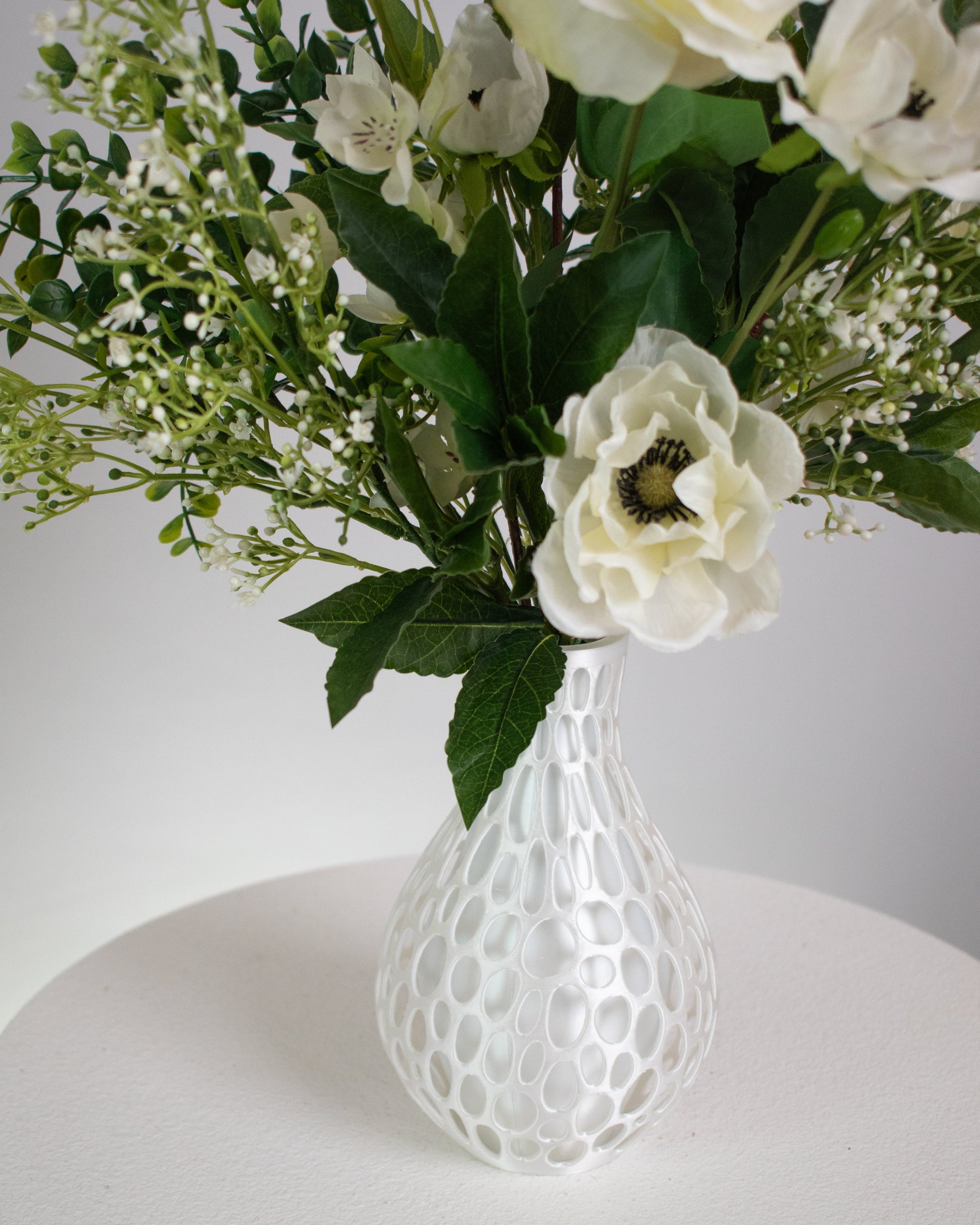 Presented in a modern honeycomb-inspired white vase, this piece blends contemporary design with natural beauty. Perfect for dining tables, entryways, or serene interiors, Ivory Bloom adds a touch of calm and refinement that never fades. With lifelike detail and zero upkeep, it’s the perfect choice for those who love beauty without the maintenance.