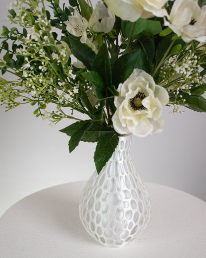 Presented in a modern honeycomb-inspired white vase, this piece blends contemporary design with natural beauty. Perfect for dining tables, entryways, or serene interiors, Ivory Bloom adds a touch of calm and refinement that never fades. With lifelike detail and zero upkeep, it’s the perfect choice for those who love beauty without the maintenance.