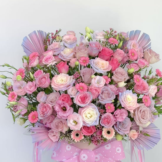 Gift flower box arrangement with roses and gerberas, finished with a pink patterned ribbon