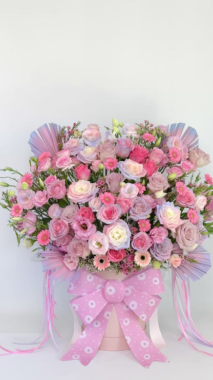 Gift flower box arrangement with roses and gerberas, finished with a pink patterned ribbon