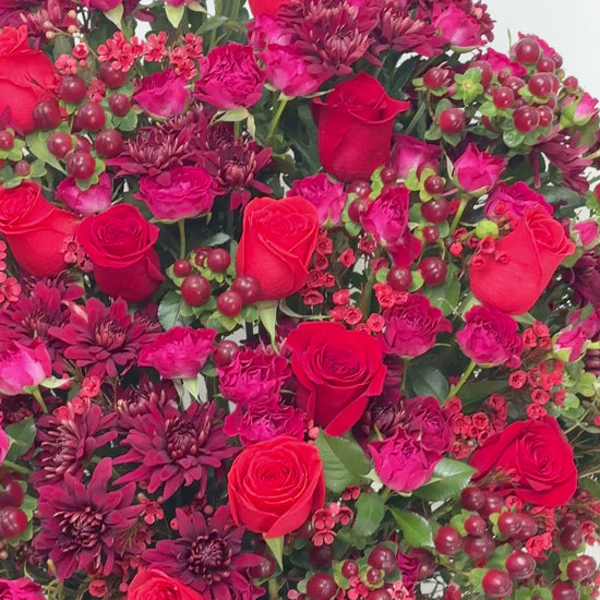 Luxury flower gift box with red roses,  blooms, and textured berry details for celebrations